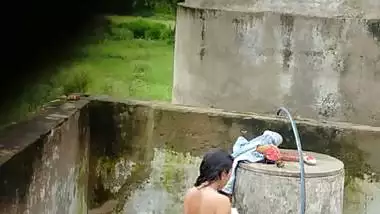 Indian village girl bathing near water tank outdoor