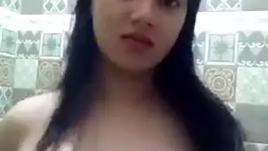 Sex model stands in front of mirror and squeezes own big natural tits